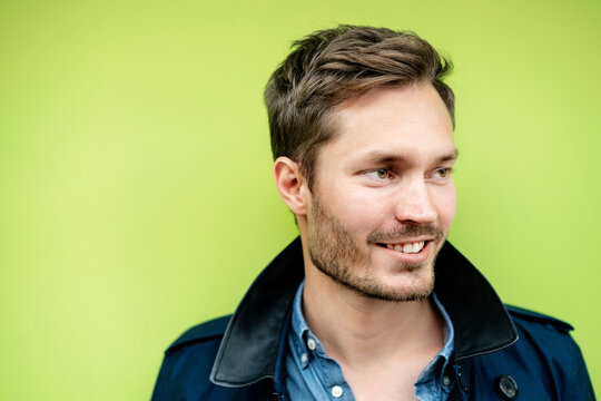 Portrait of a mid adult man, against green background