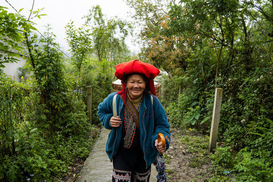 Smiling villager in traditional clothing walking in Sapa Vietnam