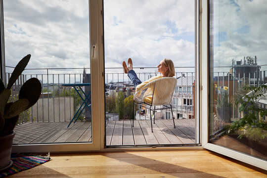 Mature woman at home relaxing on balcony