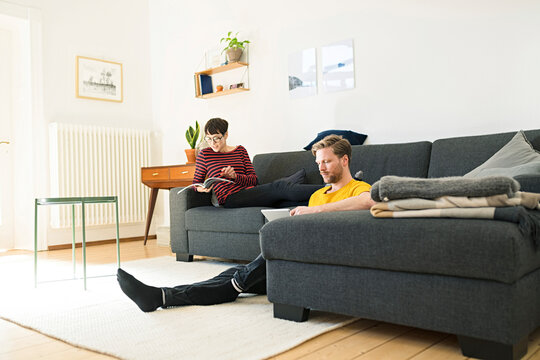 Casual couple relaxing in living room at home