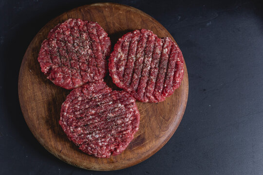 Spiced burger patties on chopping board, from above