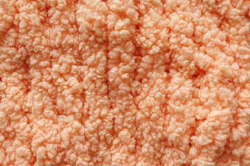 Soft peach plush yarn knitted texture background © Iryna Miadzvedzeva