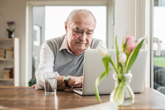 Senior man using laptop at home