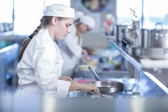 Teenage girl cooking in canteen kitchen