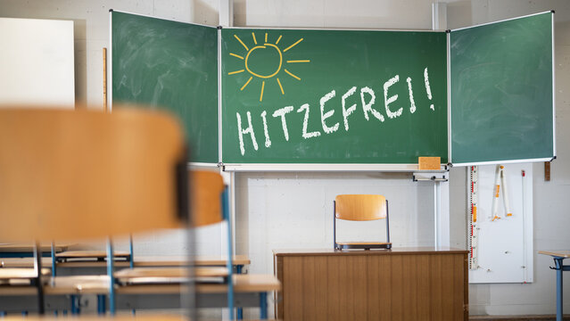 Hitzewelle in Deutschland - Text " Hitzefrei " mit Kreide Schrift auf Schultafel Kreidetafel in Klassenzimmer