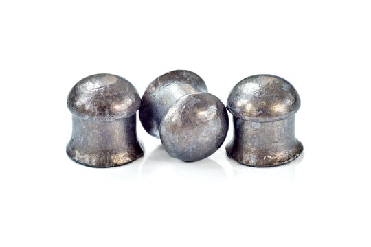 Three lead dome-head airgun pellets for hunting or sport shooting isolated on white background. Macro shot shows metallic texture and aerodynamic diabolo shape of high-quality ammunition.