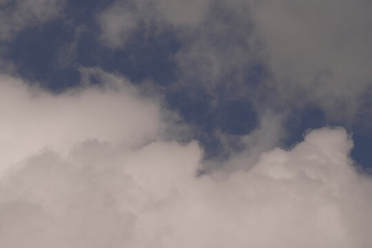 White Cumulus Clouds Drift Across a Deep Blue Daytime Sky Creating Atmospheric Aerial Background Patterns