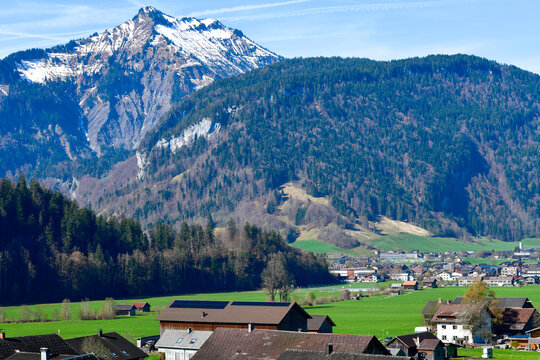 Idyllischer Blick &uuml;ber gr&uuml;ne Fr&uuml;hlingswiesen auf Bezau im Bregenzerwald vor der markanten Kulisse des Firstgrats, Vorarlberg, &Ouml;sterreich
