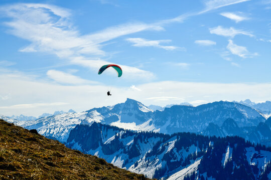 Gleitschirmflieger beim Paragliding vor der markanten Zacken-Kulisse des Annalper Stecken im Bregenzerwald, Vorarlberg, &Ouml;sterreich