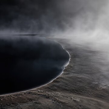 Black Geothermal Lake With Steam And Mineral Shore