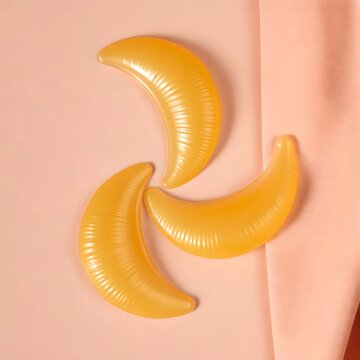 Three yellow inflatable crescent shaped pool toys on pink background  summer fun and leisure