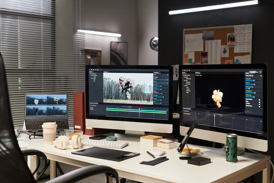 Wide shot of video editing workstation displaying explosion footage across desktop monitors and laptop, supporting post production workflow. Ideal for media agency, content creation, VFX marketing