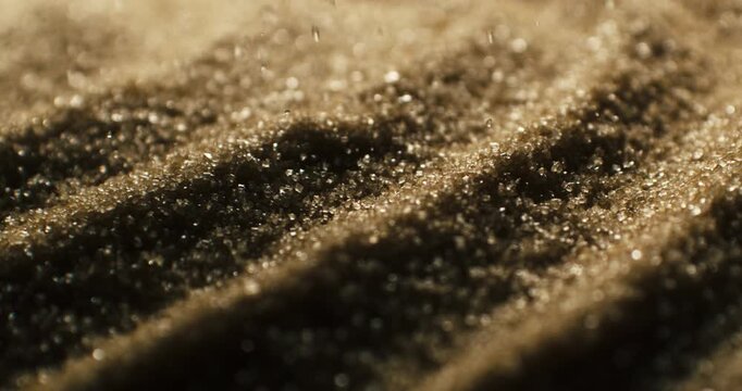 Slow Motion Macro view of sparkling brown sugar crystals with shallow depth of field.