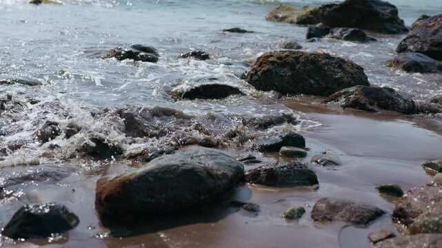 Waves are crashing onto the sandy beach