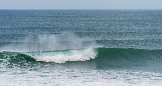 Powerful ocean waves rolling with splashes and foam.