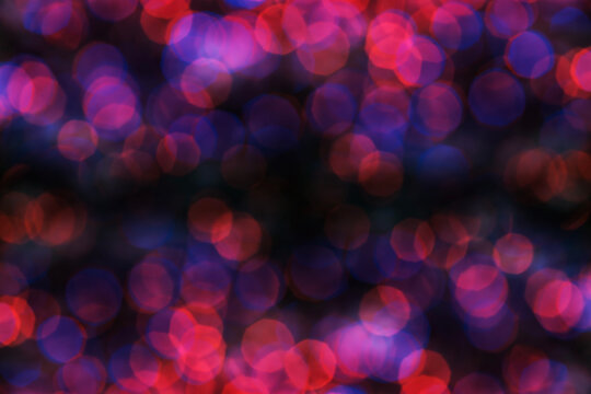 vibrant bokeh light effect background with overlapping red, purple, and pink circular highlights against a dark backdrop