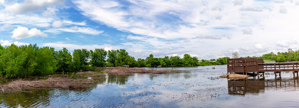 Panoramic landscape with a bird blind and cloudy sky reflected in a lake at the August A. Busch Memorial Conservation Area in St. Charles County Missouri	