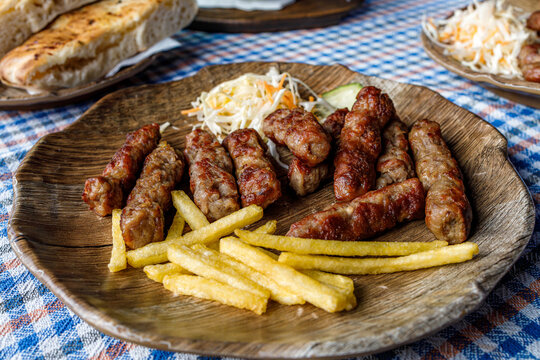 Cevapi served with fries and salad at a Balkan restaurant in the evening