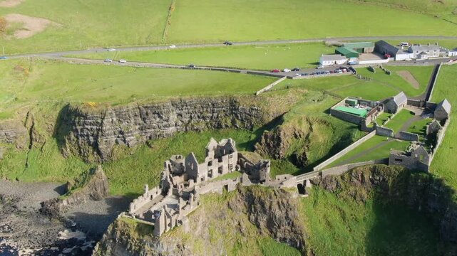 Stunning aerial perspective of Dunluce Castle, a ruined medieval fortress perched on the edge of a basalt outcropping in County Antrim