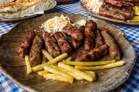 Cevapi served with fries and salad at a restaurant in a casual setting during lunch time