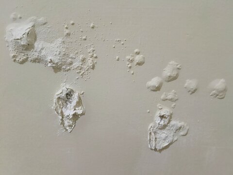 Close-up of efflorescence and paint peeling on interior wall caused by moisture damage, salt deposits, spalling plaster. Shows concrete wall dampness, mold risk. Ideal reference for waterproof repair.
