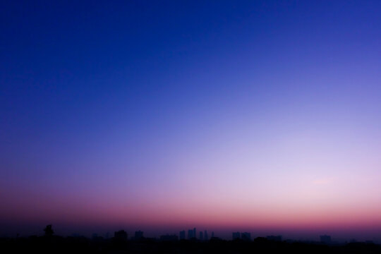 Beautiful twilight sky with blue and pink gradient over city silhouette background. horizontal shape, copy space (High resolution), real photo
