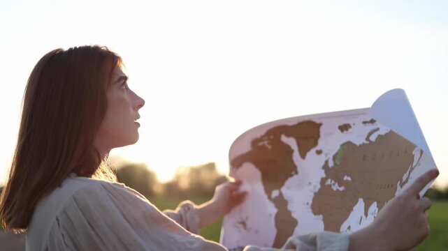 Young woman studying a world map outdoors reflecting on global challenges international cooperation sustainable development and the future of humanity