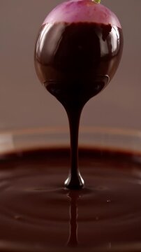 Chocolate-covered cherry in rich melted chocolate