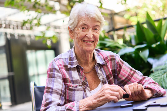 Senior woman enjoying a game outdoors in a rehabilitation facility garden