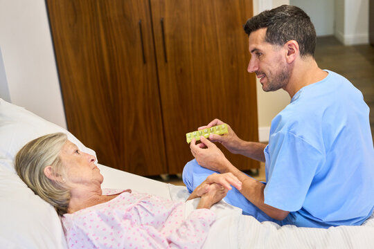 Caregiver assisting elderly patient with medication in a rehabilitation facility