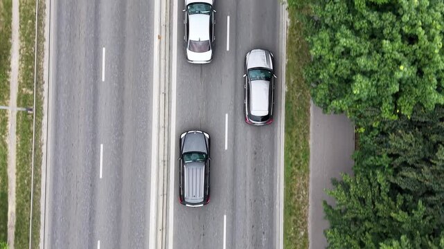 Aerial view of a traffic jam on a busy road, showcasing multiple vehicles including cars and a bus, surrounded by greenery and urban infrastructure in a vibrant setting