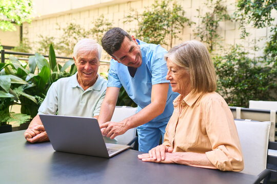 Senior residents using technology with assistance in an outdoor setting