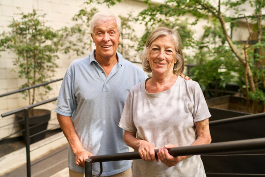 Happy senior couple posing together in a garden rehabilitation setting outdoors