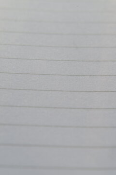 Close-up of a blank white lined paper from a notebook page.