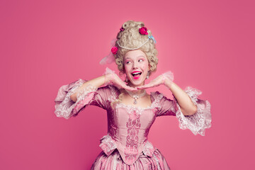 Fototapeta premium Photo of positive lady princess in antique baroque style dress hold hands near face look empty space isolated pink color background