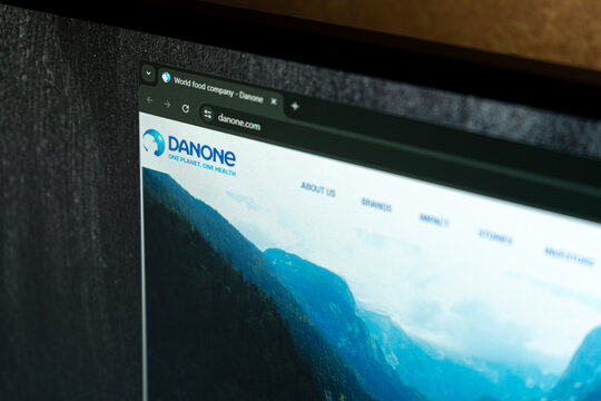 DNIPRO, UKRAINE - JULY 7, 2026: Close-up of a laptop screen displaying the Danone world food company website, showing the blue corporate logo and "One Planet. One Health" slogan.