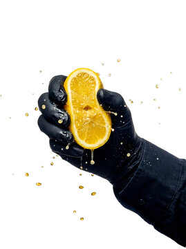 Gloved hand squeezing fresh lemon with splashing juice, transparent background