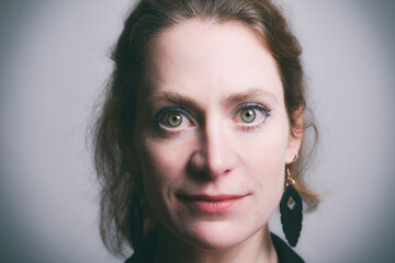 Fototapeta premium Authentisches Porträt einer selbstbewussten Frau mit direktem Blick in die Kamera. Natürliche Schönheit, Emotion, Persönlichkeit, modernes Studioporträt und ausdrucksstarke People-Fotografie.