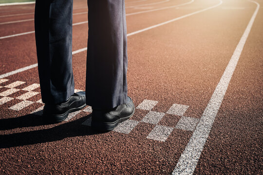 Businessman feet in leather shoes standing at the start line on a running track. Concept of business competition, corporate start, career challenge, and ready to race.