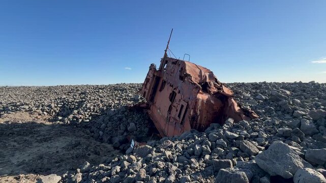 Weathered shipwreck resting on the rocky shoreline of Hopsnes, Iceland, near Grindavik on a beautiful sunny day in the land of fire and ice