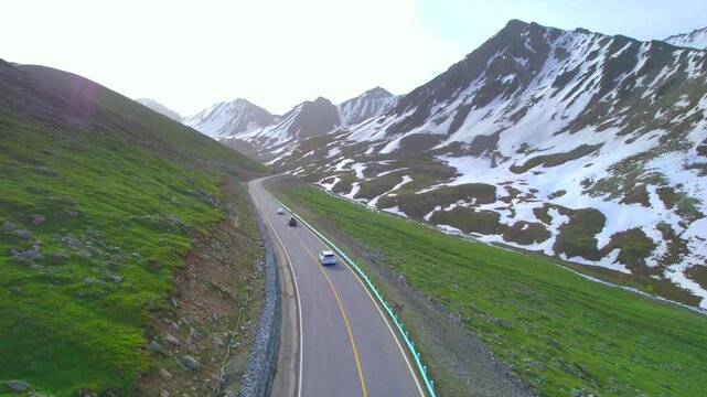 Xinjiang's Duku Highway: natural scenery in Xinjiang, China, featuring snow-capped mountains, canyons, and winding mountain roads.