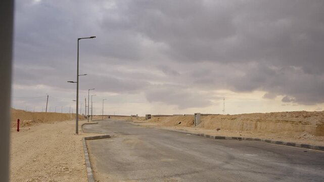 Abandoned street in desert with half finished construction and roads deserted in the middle of project. Housing infrastructure or developing community in desert building neighborhood in remote town