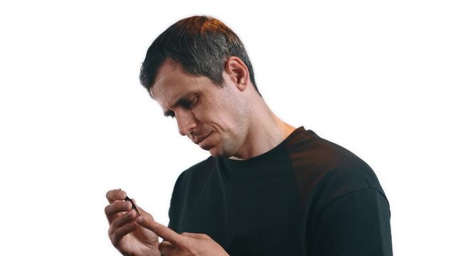 Man carefully removing a tiny splinter from his finger using tweezers
