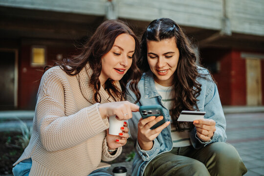 Women friends online shopping paying with credit card