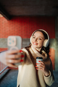 Young woman taking a selfie smiling wearing headphones