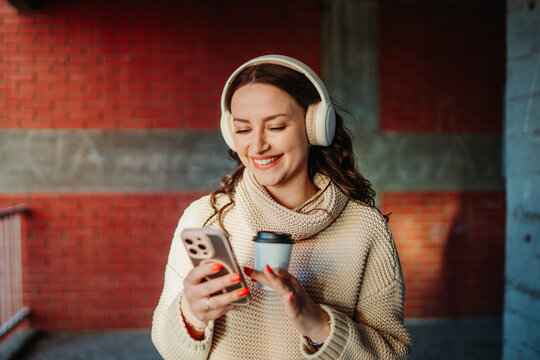 Woman enjoying music and coffee in urban street
