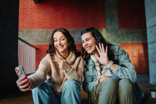 Young women enjoying video call on smartphone together
