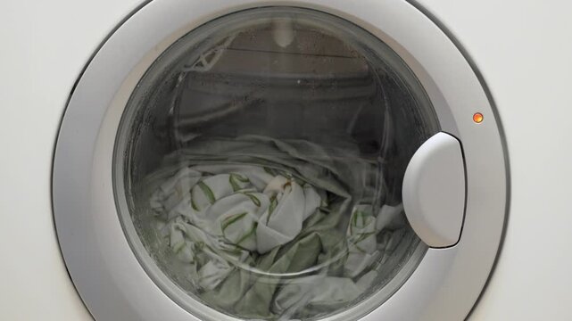 Water fills the washing machine drum during the laundry process. This is the washing cycle at home.