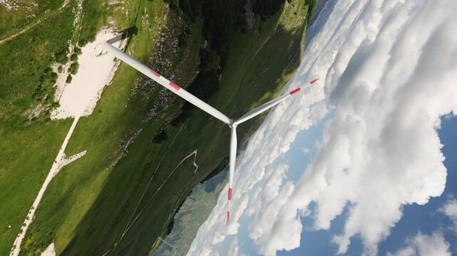 aerial drone shot rolling in sync with wind turbine blades so they appear frozen while the green hilltop and sky spin around, a hypnotic optical illusion of renewable energy, Krnovo, Montenegro