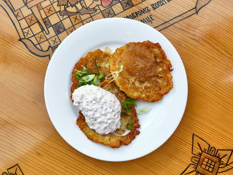 Traditional Belarusian potato pancakes draniki with pike caviar and sour cream on plate